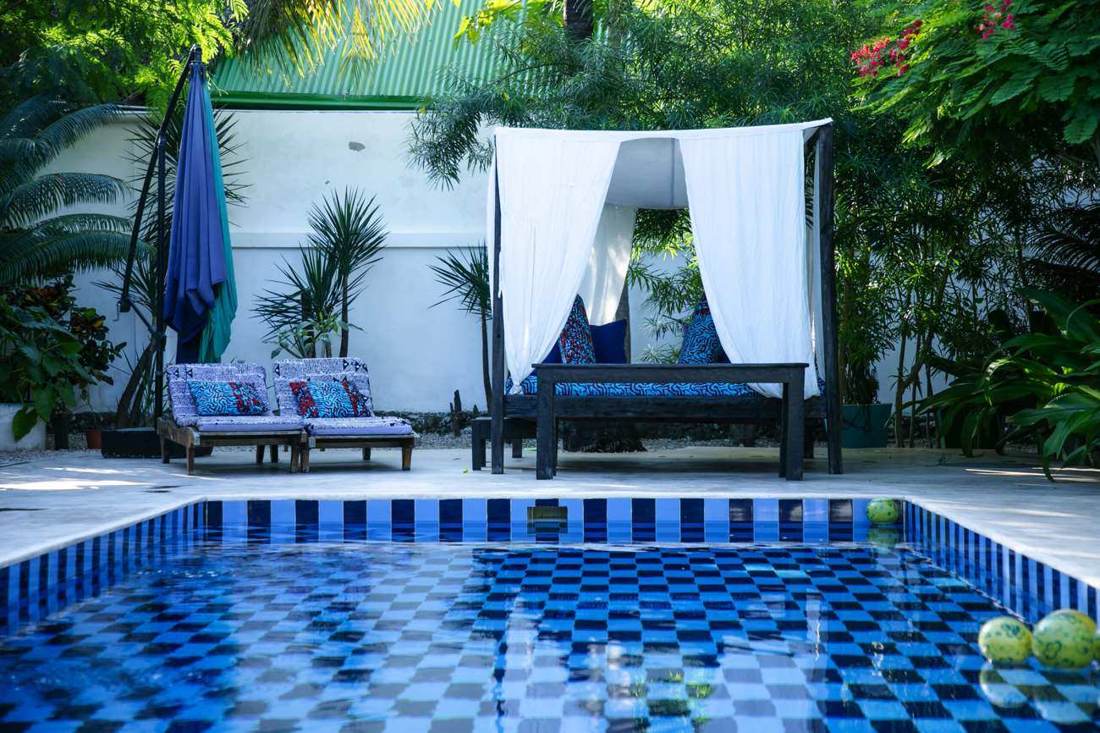 Mosaic garden pool with shaded daybed
